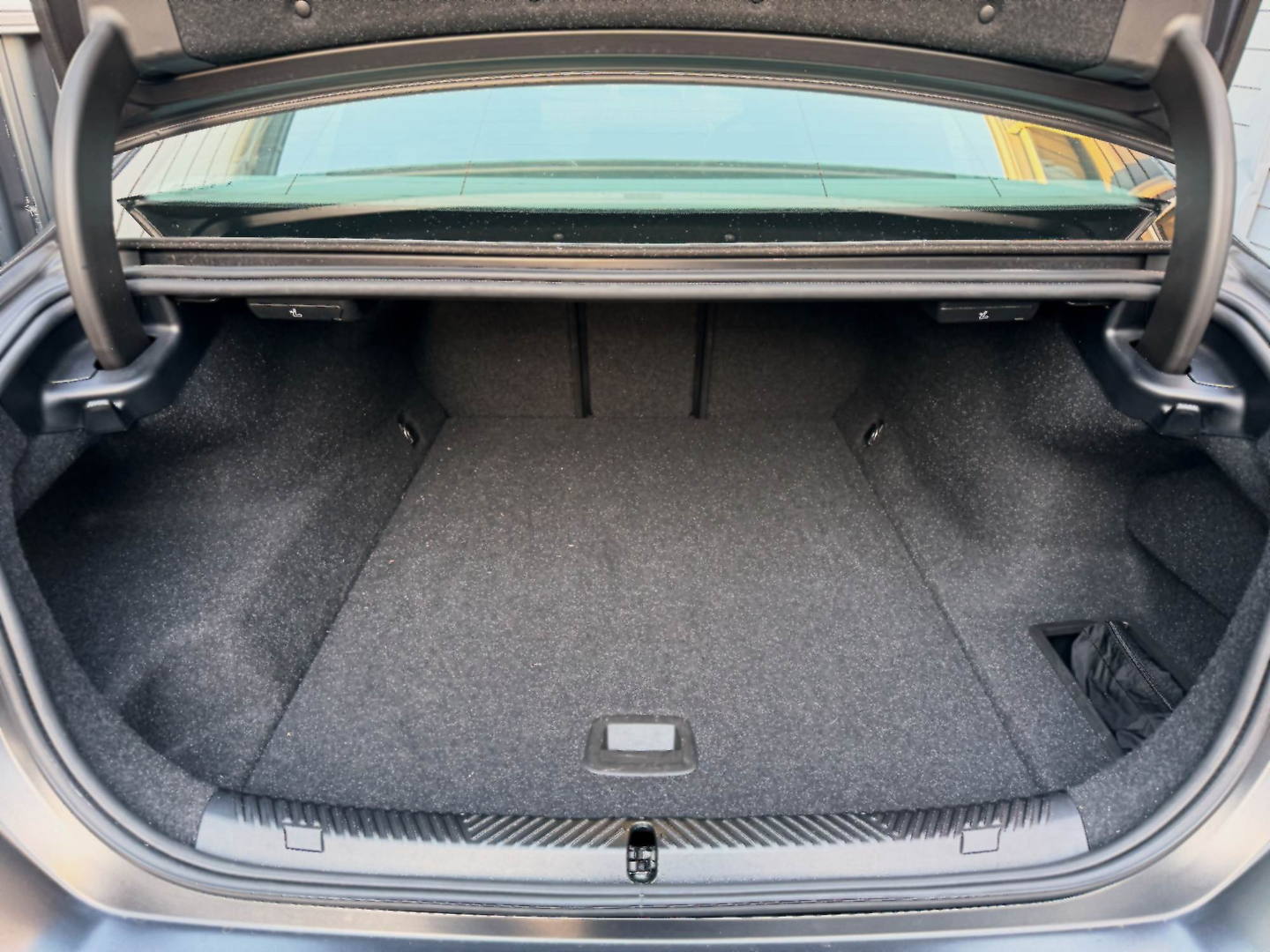 The open boot of the OSPIPO sedan with two large checked suitcases loaded inside